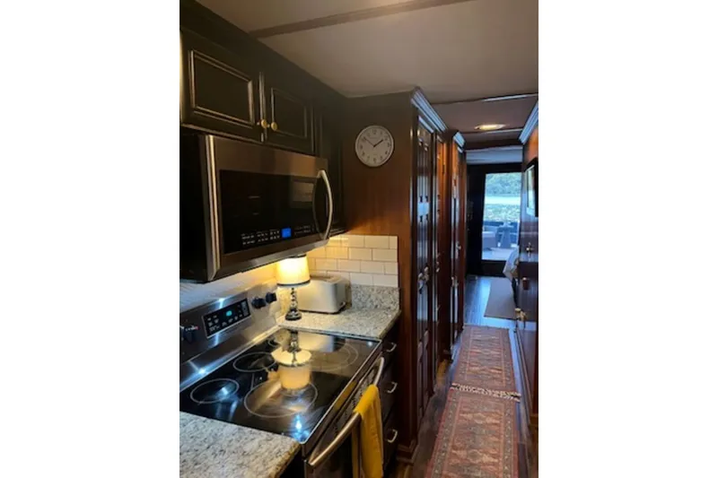 Slide: The Image of 1985 Sumerset 18x81 houseboat kitchen with modern appliances and cozy decor. - 18