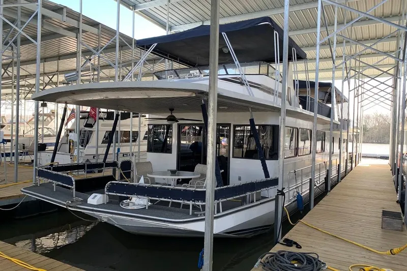 Slide: The Image of 1985 Sumerset 18x81 houseboat docked under covered marina. - 2