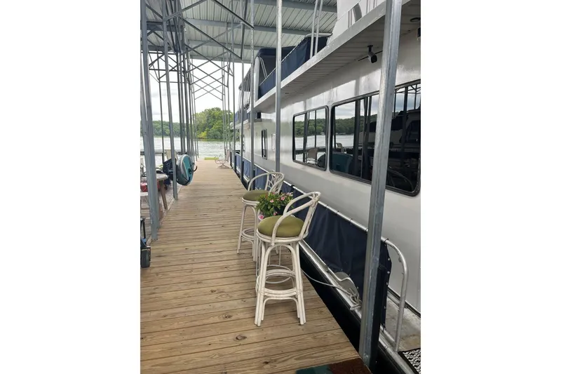 Slide: The Image of 1985 Sumerset 18x81 houseboat docked with outdoor seating and scenic lake view. - 31