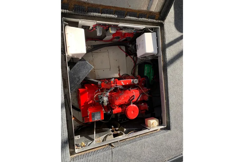 Slide: The Image of Engine compartment of a 1985 Sumerset 18x81 houseboat, featuring a red engine. - 32