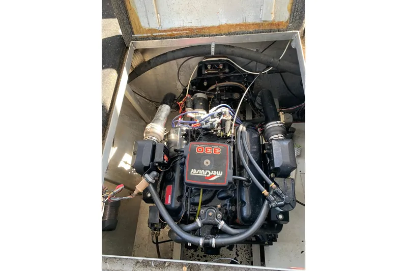 Slide: The Image of Engine compartment of a 1985 Sumerset 18x81 houseboat, featuring a MerCruiser 330 engine. - 34