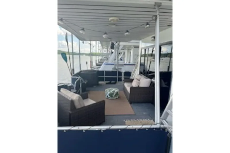 Slide: The Image of 1985 Sumerset 18x81 houseboat with outdoor seating on a serene lake. - 7