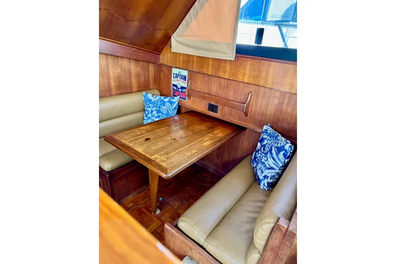 Slide: The Image of Cozy dining area in 1988 Viking 48 Convertible yacht with wood table and blue cushions. - 29