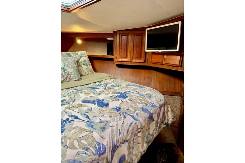 Slide: The Image of Cozy bedroom in 1988 Viking 48 Convertible yacht with floral bedding and wooden cabinetry. - 32