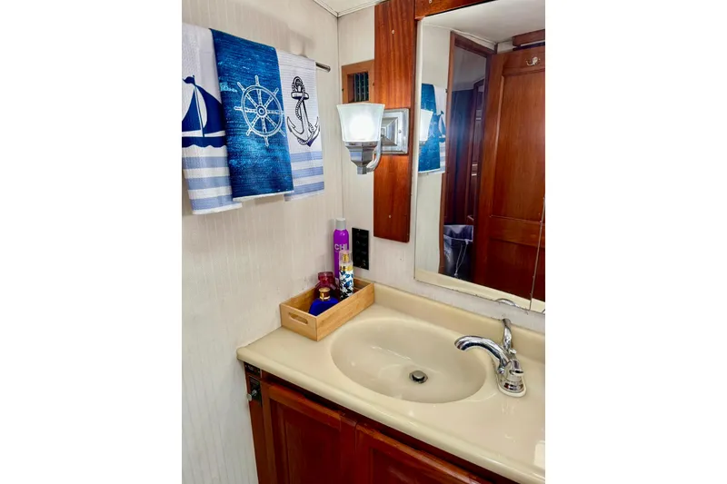 Slide: The Image of Bathroom sink area in a 1988 Viking 48 Convertible yacht with nautical-themed towels. - 34