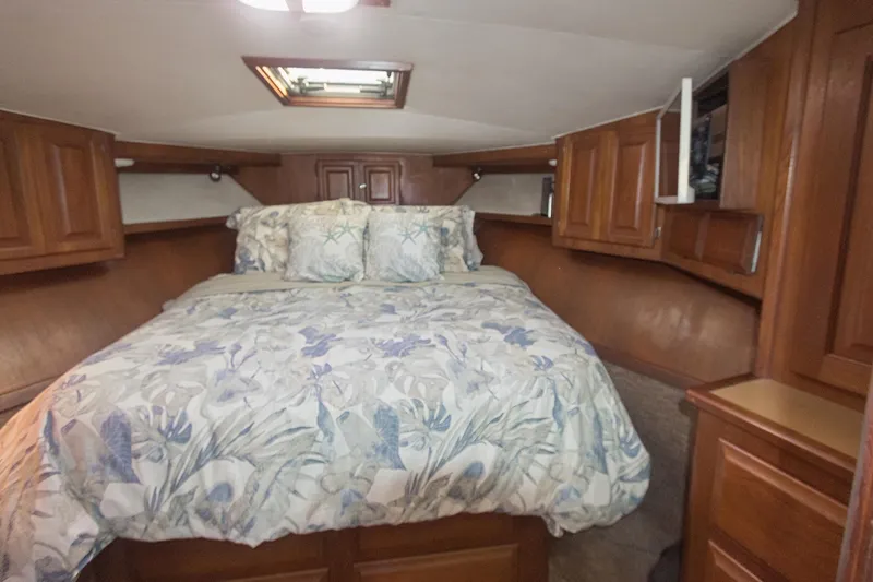 Slide: The Image of Cozy bedroom in 1988 Viking 48 Convertible yacht with wooden cabinets and floral bedding. - 44
