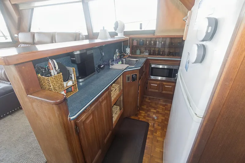 Slide: The Image of 1988 Viking 48 Convertible yacht kitchen with wooden cabinetry, appliances, and countertop accessories. - 47