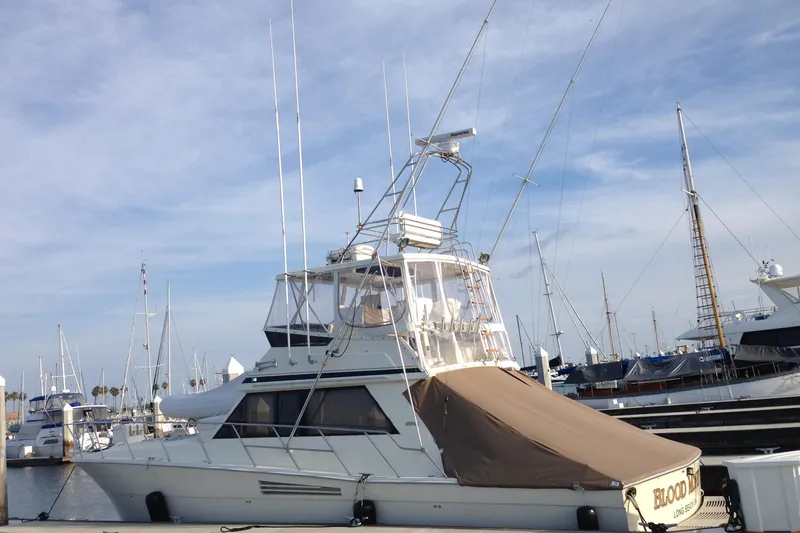 Slide: The Image of 1988 Viking 48 Convertible yacht docked at a marina under a clear sky. - 5