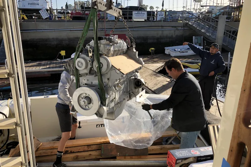 Slide: The Image of Men installing engine on 1988 Viking 48 Convertible boat at marina. - 53
