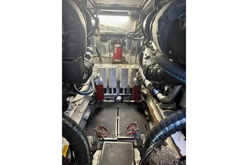 Slide: The Image of Engine room of a 1988 Viking 48 Convertible yacht, showcasing mechanical components and piping. - 57
