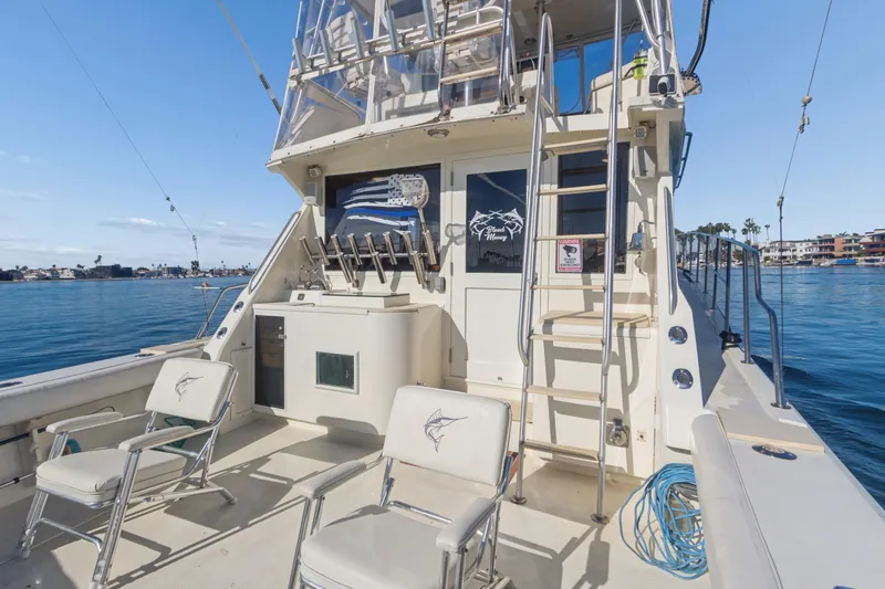 Slide: The Image of 1988 Viking 48 Convertible yacht deck with chairs, ladder, and ocean view. - 7