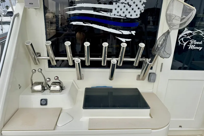 Slide: The Image of 1988 Viking 48 Convertible boat cockpit with fishing rod holders and control panel. - 8