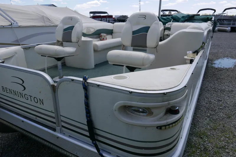 The Image of 2005 Bennington 257FS pontoon boat with seating, parked on gravel. - 0