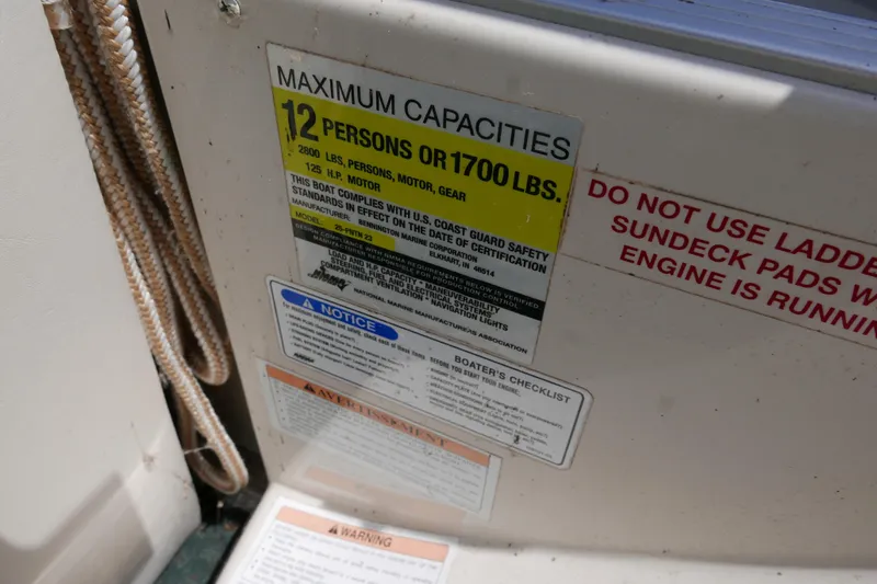 Slide: The Image of 2005 Bennington 257FS capacity label, 12 persons or 1700 lbs, safety warnings visible. - 10