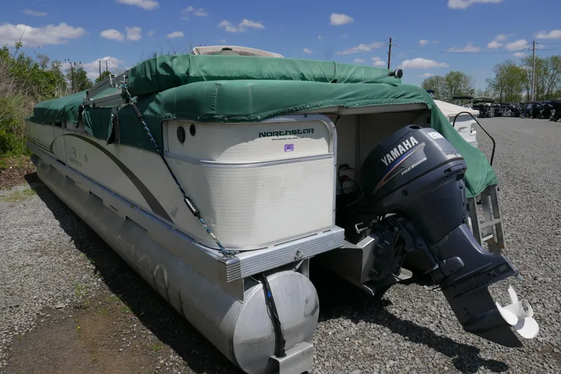 Slide: The Image of 2005 Bennington 257FS pontoon boat with Yamaha outboard motor, covered and parked on gravel. - 13