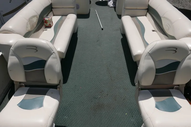 Slide: The Image of Interior seating of a 2005 Bennington 257FS boat with white and teal upholstery. - 3