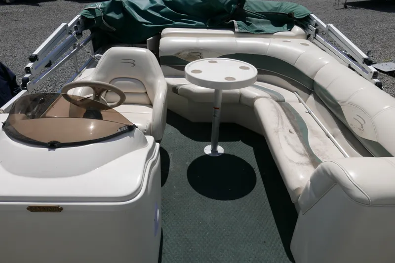 Slide: The Image of 2005 Bennington 257FS boat interior with seating and table, featuring a captain's helm. - 5