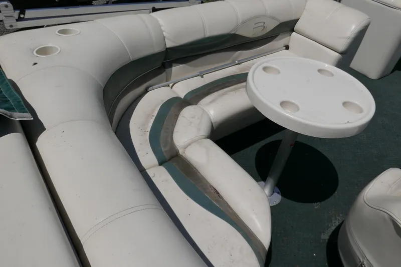 Slide: The Image of 2005 Bennington 257FS boat interior with white seating and round table. - 8