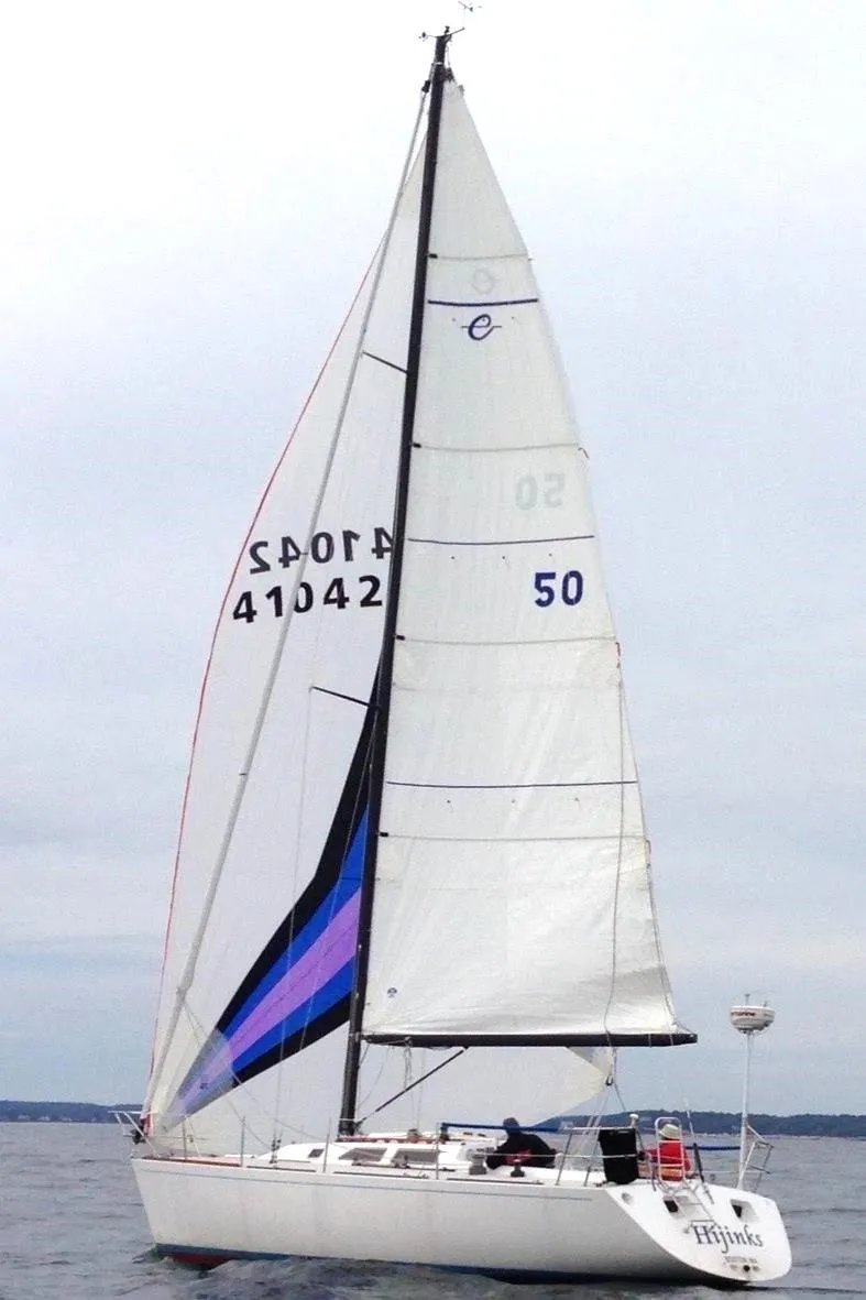 Slide: The Image of Sailboat Express 37, 1986 model, sailing on open water with white sails. - 1