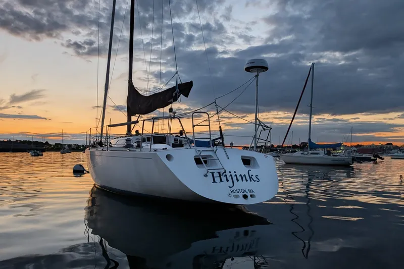 Slide: The Image of Sailboat "Hijinks" on calm water at sunset, Express 37, 1986 model. - 2