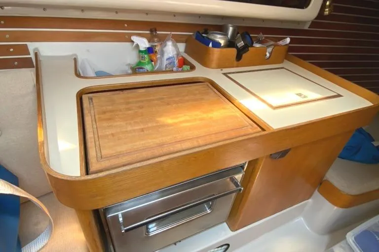 Slide: The Image of Compact galley kitchen in 1986 Express 37 sailboat with wooden countertop and storage. - 31
