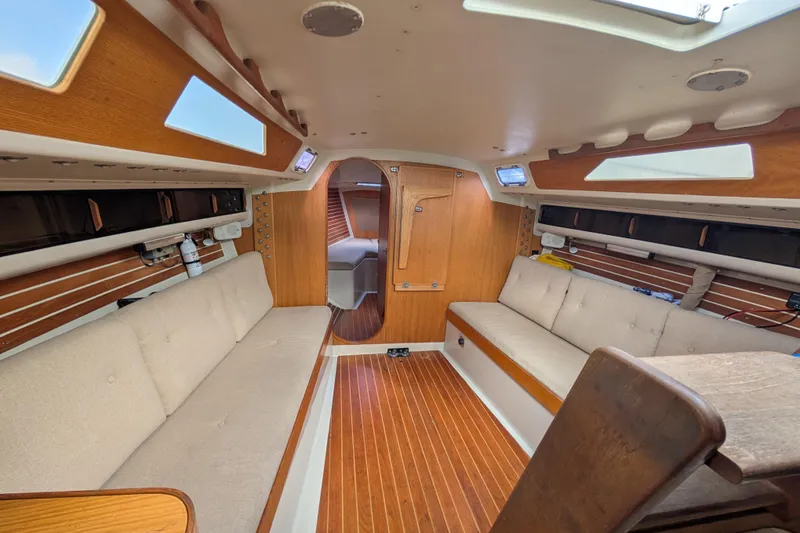 Slide: The Image of Interior of 1986 Express 37 sailboat with wooden finish and cushioned seating. - 45