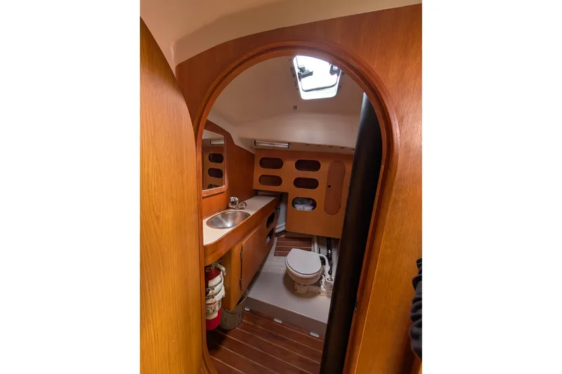 Slide: The Image of Interior of 1986 Express 37 sailboat bathroom with wooden finish and compact design. - 48
