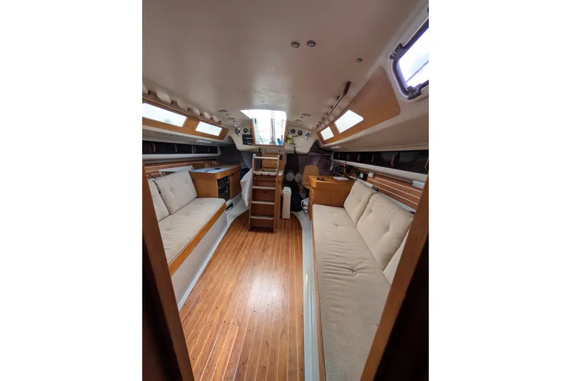 Slide: The Image of 1986 Express 37 yacht interior with wooden flooring and cushioned seating. - 49