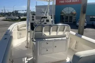 Slide: The Image of 2022 Cobia 237 Center Console boat at dealership, showcasing helm and seating area. - 12