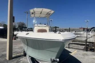 Slide: The Image of 2022 Cobia 237 Center Console boat in a marina under clear blue sky. - 3