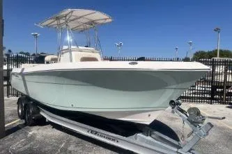 Slide: The Image of 2022 Cobia 237 Center Console boat on trailer, parked outdoors under clear blue sky. - 4