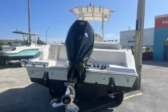 Slide: The Image of 2022 Cobia 237 Center Console boat with powerful outboard motor in a parking lot. - 5
