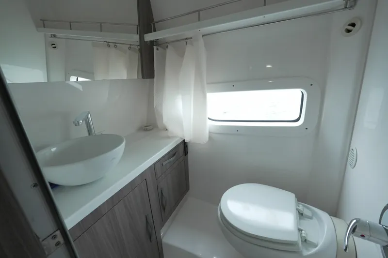Slide: The Image of Modern bathroom in 2021 Regal 33 XO yacht with sink, toilet, and window. - 19