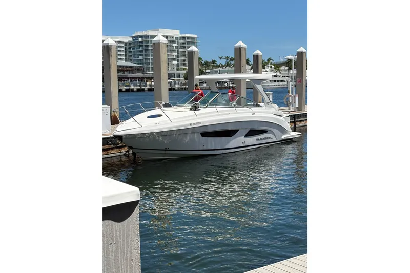 Slide: The Image of 2021 Regal 33 XO boat docked at marina with modern buildings in background. - 3