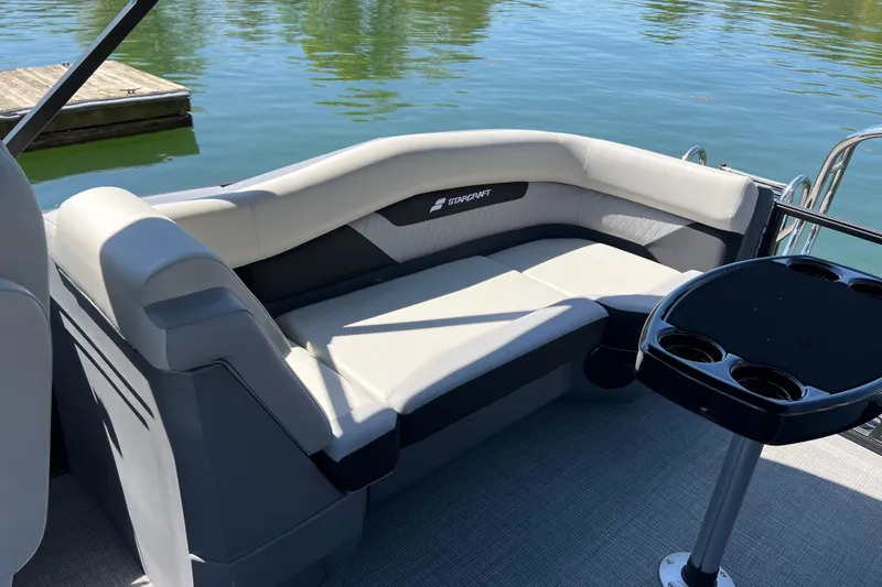 Slide: The Image of 2026 Starcraft VX 22 R DH pontoon boat interior with plush seating and cupholder table. - 10