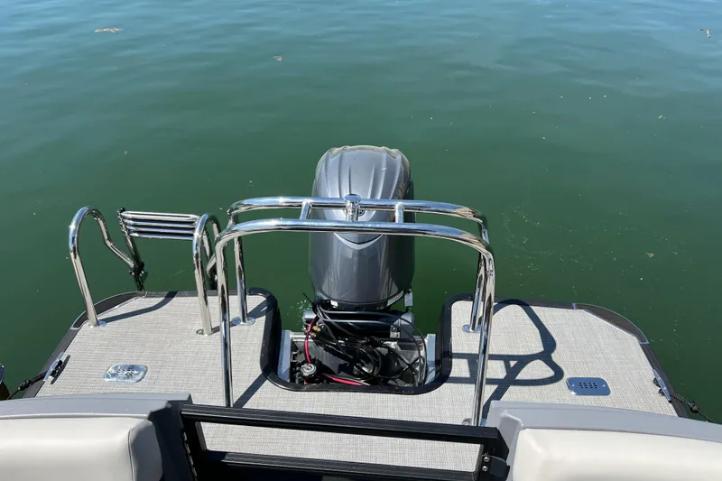 Slide: The Image of 2026 Starcraft VX 22 R DH boat stern with motor on calm water. - 11