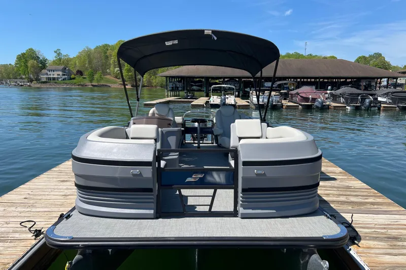 Slide: The Image of 2026 Starcraft VX 22 R DH pontoon boat docked on a sunny lake. - 2