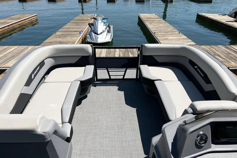Slide: The Image of 2026 Starcraft VX 22 R DH pontoon boat interior with spacious seating at a marina. - 5