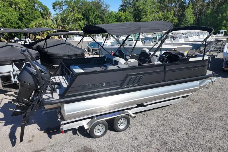 Slide: The Image of 2026 Viaggio Diamante S 22 pontoon boat on trailer, surrounded by other boats. - 2