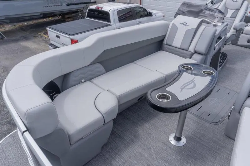 Slide: The Image of 2026 SunCatcher Elite 326 SL pontoon boat interior with plush seating and cupholder table. - 16