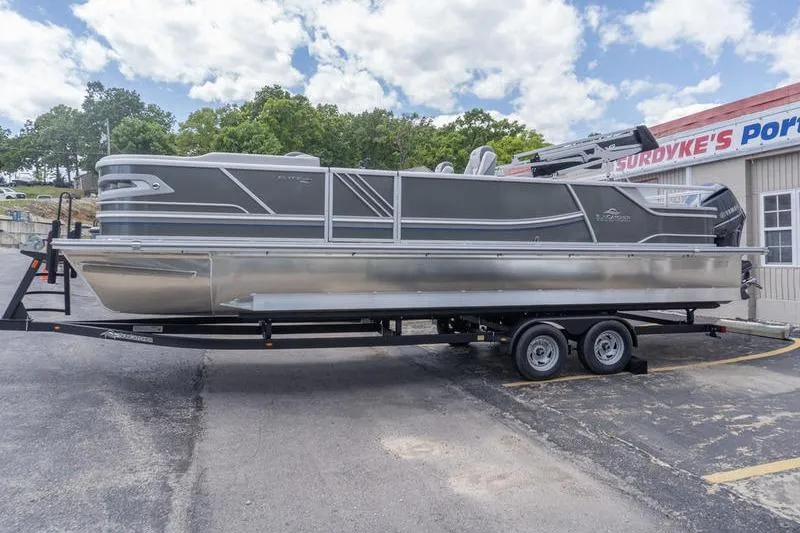 Slide: The Image of 2026 SunCatcher Elite 326 SL pontoon boat on trailer, parked outside dealership. - 3