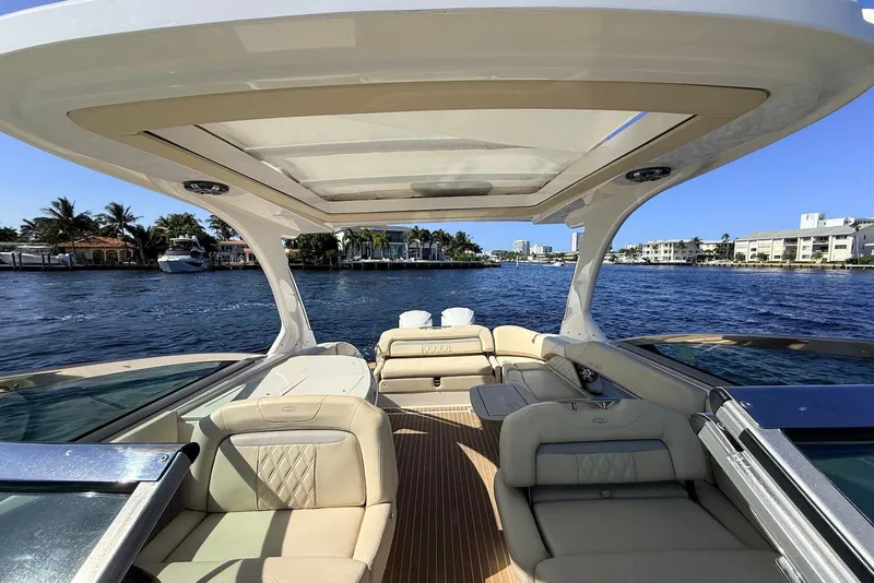Slide: The Image of 2019 Regal 33 OBX boat interior with luxurious seating on a sunny day. - 11