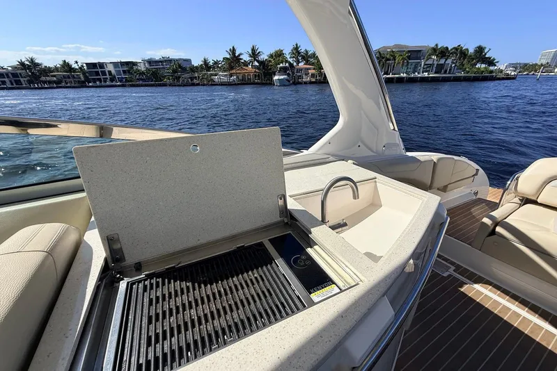 Slide: The Image of 2019 Regal 33 OBX boat with outdoor kitchen and scenic waterfront view. - 12