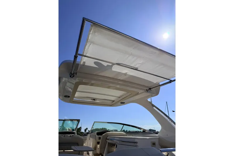 Slide: The Image of 2019 Regal 33 OBX boat with sunshade canopy under clear blue sky. - 15