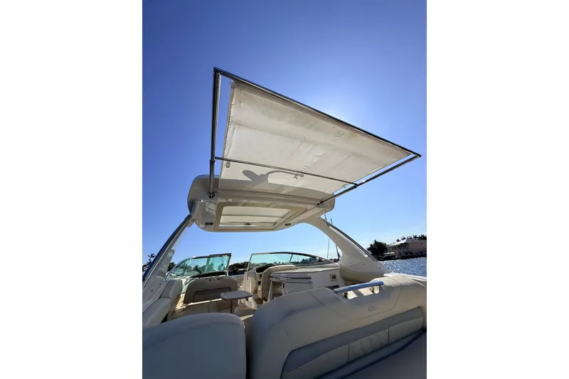 Slide: The Image of 2019 Regal 33 OBX boat interior with open sunshade, under clear blue sky. - 16