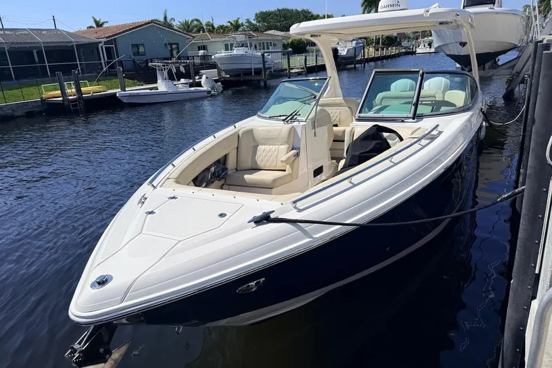 Slide: The Image of 2019 Regal 33 OBX boat docked on a calm canal, featuring sleek design and spacious seating. - 2