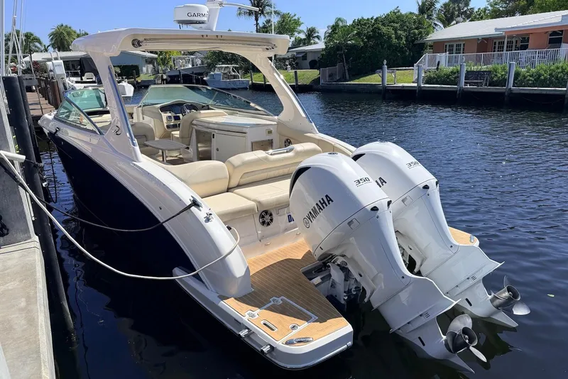 Slide: The Image of 2019 Regal 33 OBX boat with twin Yamaha 350 engines docked by a canal. - 4