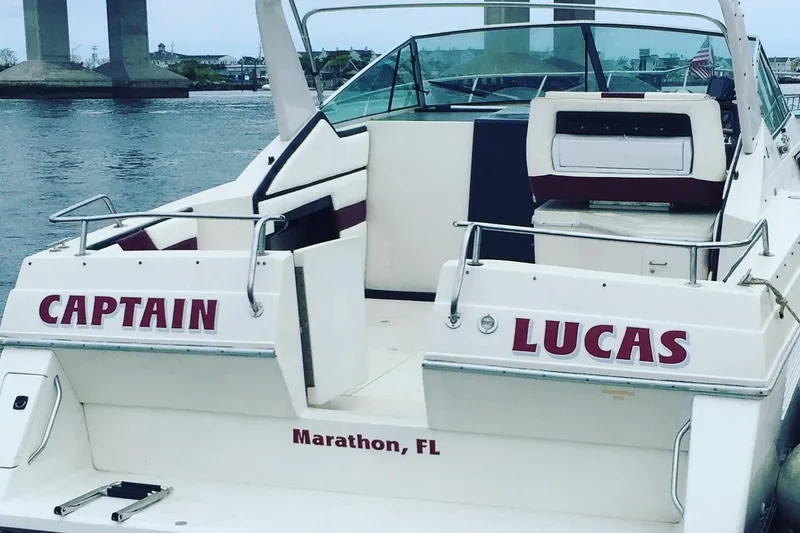 The Image of 1989 Wellcraft 3200 St. Tropez boat docked in Marathon, FL, with "Captain Lucas" signage. - 1