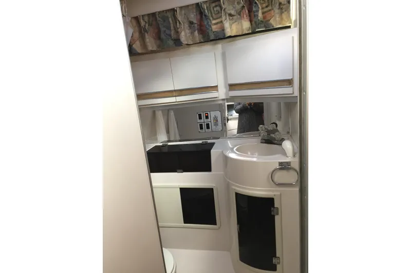 Slide: The Image of 1989 Wellcraft 3200 St. Tropez boat bathroom interior with sink and storage cabinets. - 14