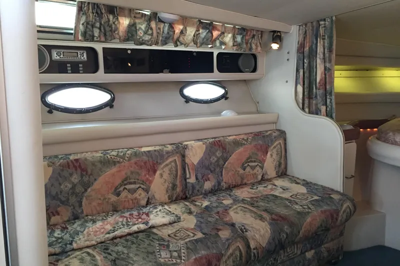 Slide: The Image of Interior of 1989 Wellcraft 3200 St. Tropez with patterned sofa and porthole windows. - 18